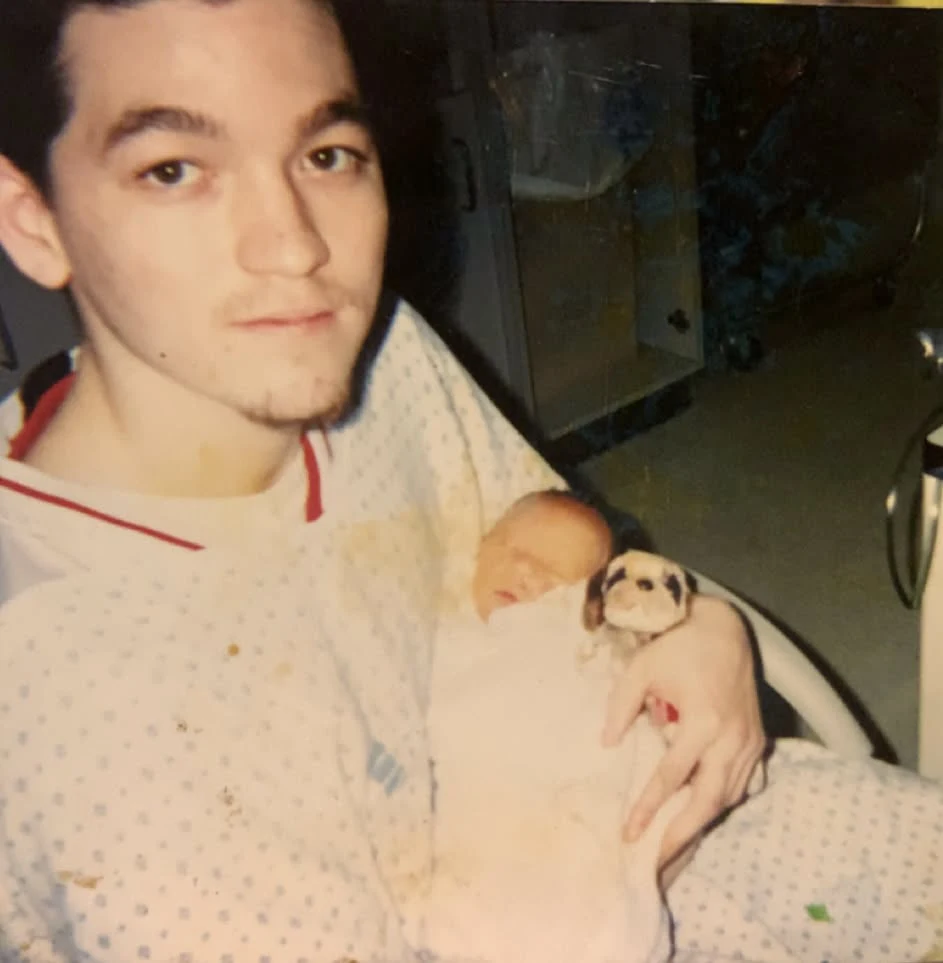 His dad holding him as an infant.
